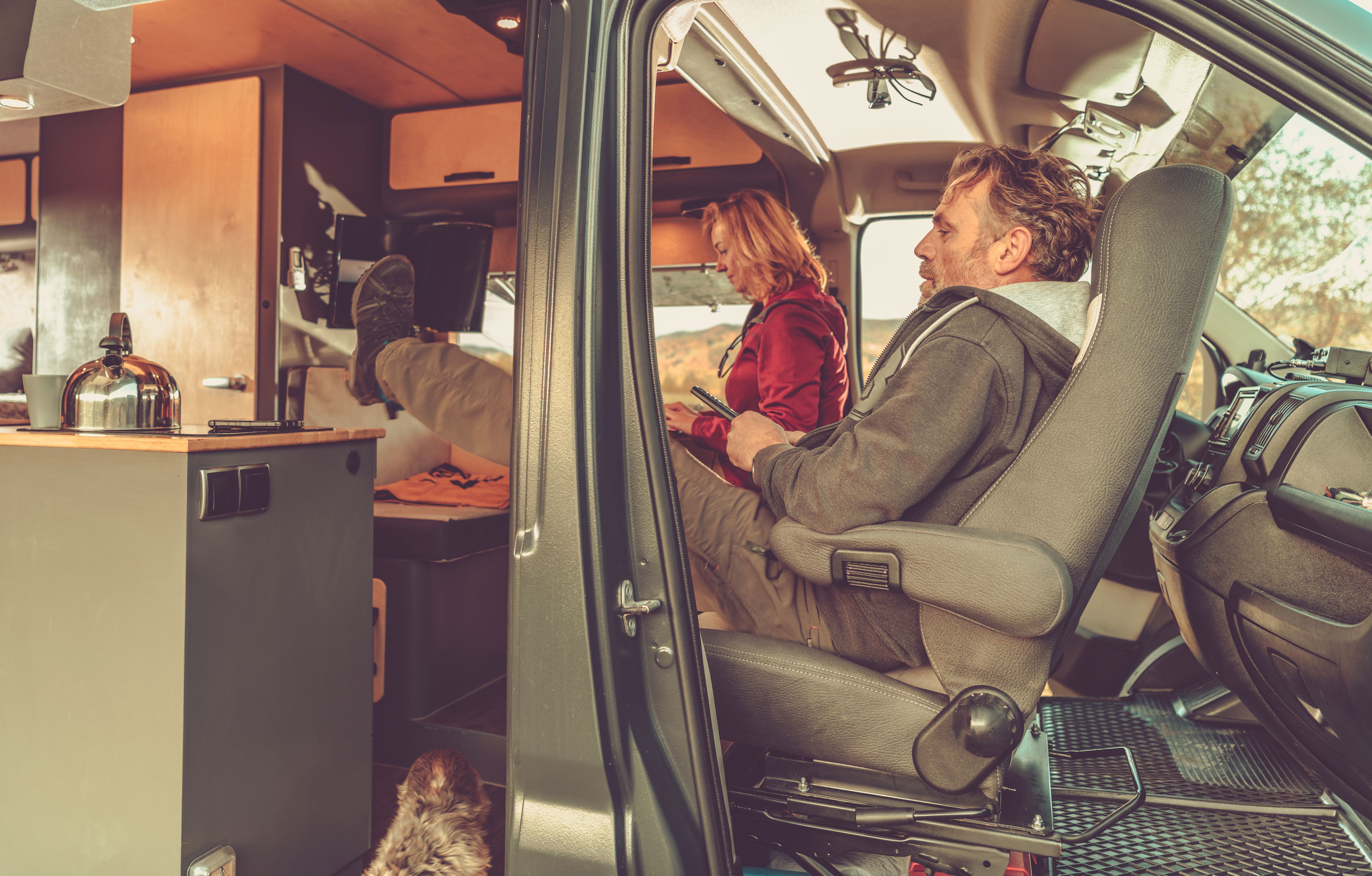 A family relaxing inside their camper van while traveling as digital nomads, enjoying van life freedom.